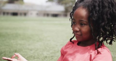 Young girl playing on grassy field outdoors