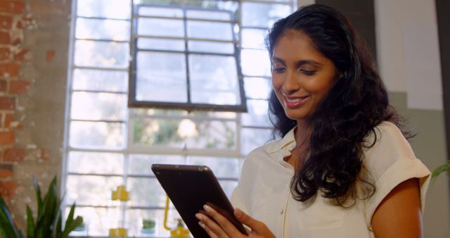 Smiling Woman Using Digital Tablet in Bright Room - Download Free Stock Images Pikwizard.com