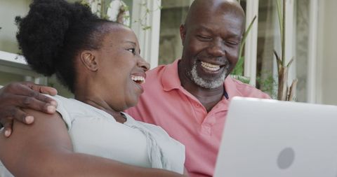 Happy Senior African American Couple Using Laptop at Home