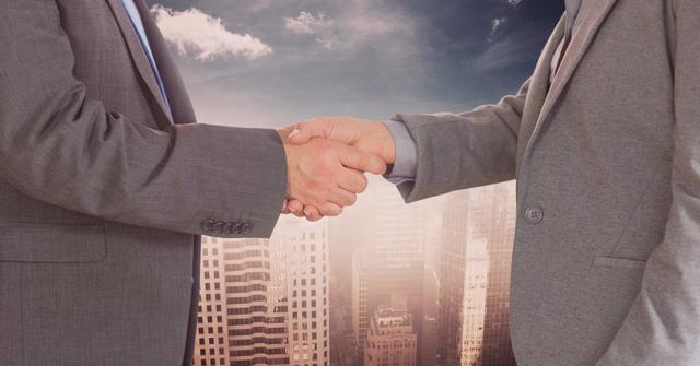 A midsection view of two businessmen shaking hands with a cityscape in the background. This image conveys themes of business partnerships, corporate agreements, and professional collaboration. It can be effectively used for business websites, presentations, advertisements, and publications that emphasize corporate services, deal-making, and professional relationships.