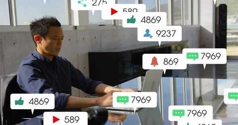 Typing content creator working on laptop with social media notifications in modern office