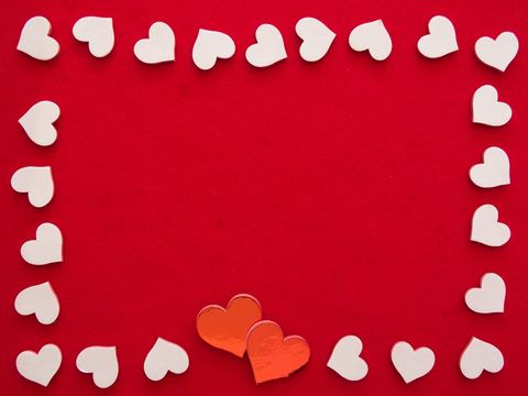 Frame of white hearts on red background with two red hearts