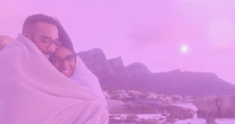 Couple Enveloped in Warmth with Dreamy Scenic Backdrop