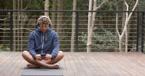 Relaxed Young Man Meditating Outdoors with Headphones