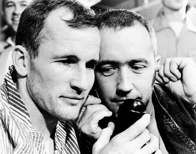 S65-33533 (7 June 1965) --- The Gemini-4 prime crew, astronauts Edward H. White II (left), pilot; and James A. McDivitt, command pilot, listen to the voice of President Lyndon B. Johnson as he congratulated them by telephone on their successful four-day, 62-revolution Gemini-4 mission. They are shown aboard the aircraft carrier USS Wasp just after their recovery from the Atlantic.