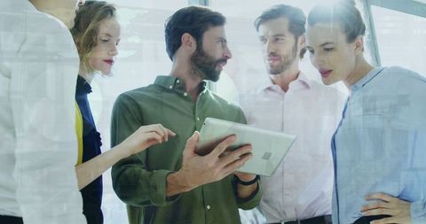 Multiracial Team Analyzing Data with Tablet in Modern Office