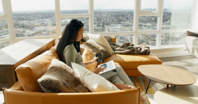 Woman Relaxing with Book and Coffee in Modern Apartment with City View - Download Free Stock Images Pikwizard.com