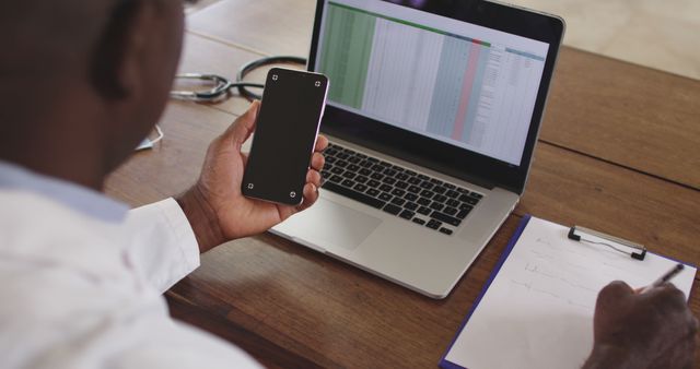 Medical professional using smartphone and laptop in office - Download Free Stock Images Pikwizard.com