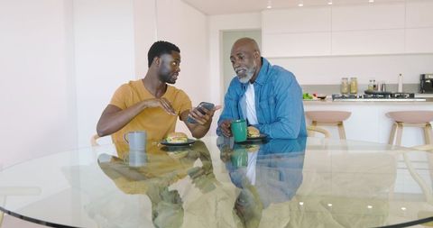 Father and Son Bonding Over Breakfast and Smartphones