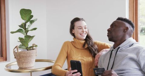 Happy Multiracial Couple Online Shopping with Smartphone and Credit Card