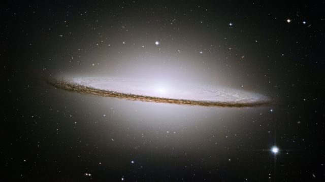 Sombrero Galaxy (Messier 104) viewed nearly edge-on, showcasing its bright core surrounded by explicit dust lanes. This impressive image highlights the galaxy's razor-sharp spiral structure. Ideal for use in educational materials, documentaries, and space-related visual content.