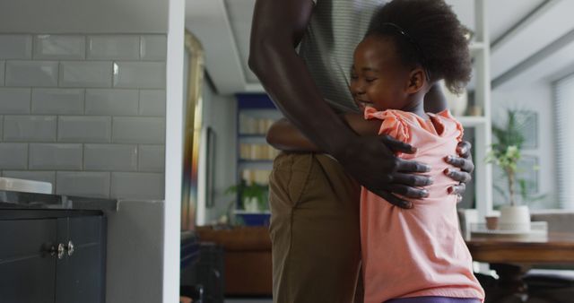 Image of african american father and daughter dancing. Enjoying quality family time together at home.