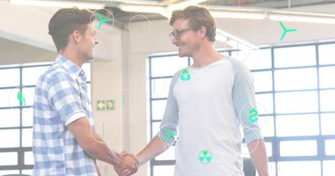 Colleagues shaking hands in modern office with ar icons showing collaboration