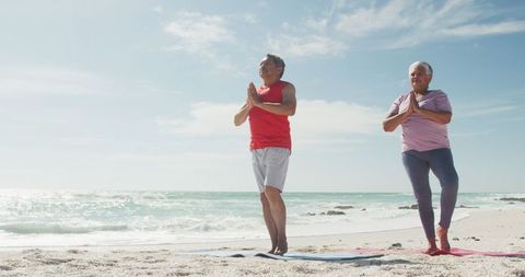 Senior Couple Practicing Yoga on Beach for Active Retirement
