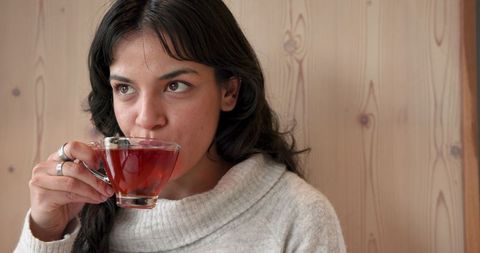 Cozy season: woman enjoys warm tea for relaxation in minimalist interior