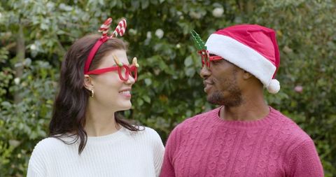 Festive Couple in Fun Glasses Enjoying Holiday Celebration Outdoors