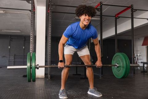 Athletic Man Powerlifting Barbell in Modern Gym