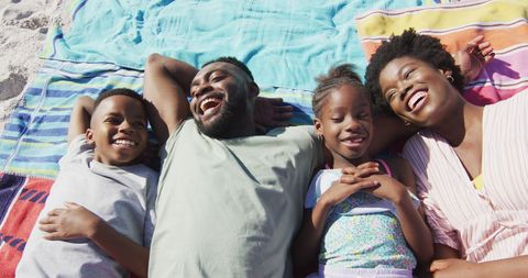 Family Laughing Together on Colorful Beach Blanket