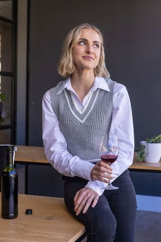 Sophisticated woman enjoying red wine in modern tasting lounge