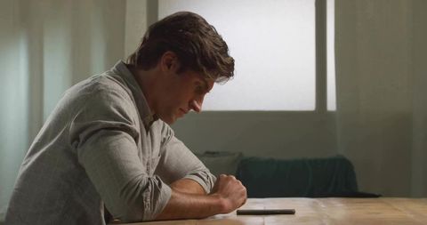 Man Focusing on Smartphone in Calming Living Room Setting