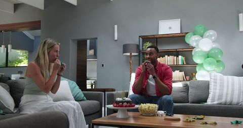 Couple Preparing for Celebration with Balloons and Snacks