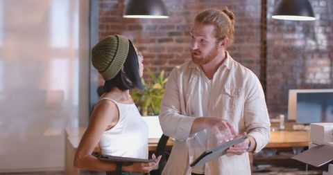 Diverse Colleagues Collaborating with Tablets in Modern Office