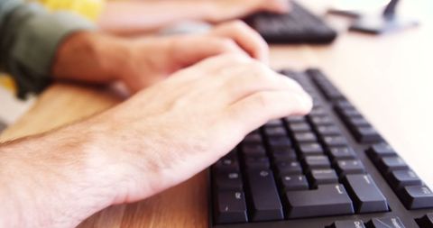 Close-up of hands typing on keyboard for productivity concept