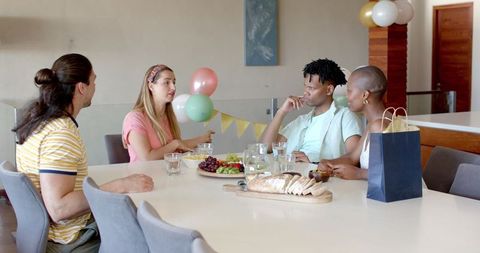 Friends Enjoying Indoor Gathering with Drinks and Snacks