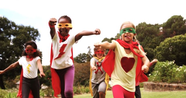 A diverse group of children dressed in superhero costumes play outdoors, with copy space. Their vibrant capes and masks add a playful and imaginative touch to a fun day at the park.