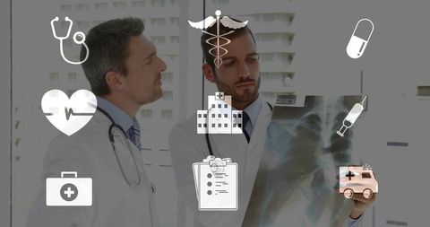 Two doctors examining chest x-ray and consulting on diagnosis in hospital by window with medical ico