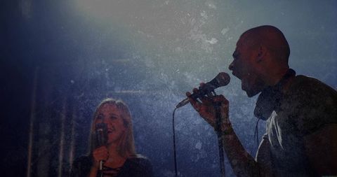 Energetic vocalists performing on hazy concert stage