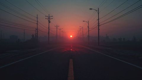 Misty Sunrise Over Road with Glowing Sun and Power Lines