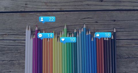 Vibrant Colored Pencils with Social Media Engagement Icons on Wooden Background