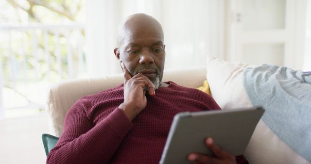 Senior man reading tablet at home on sofa - Download Free Stock Images Pikwizard.com