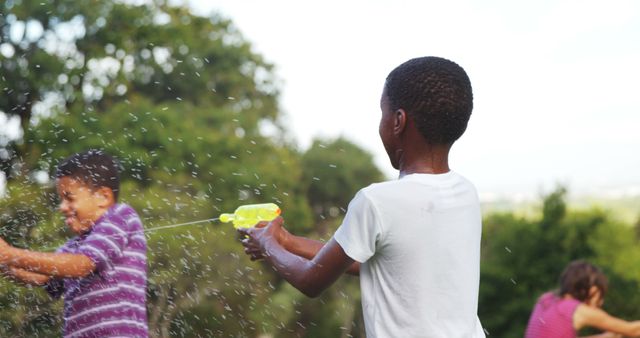 Children Having Fun Outdoors with Water Guns on a Sunny Day - Download Free Stock Images Pikwizard.com