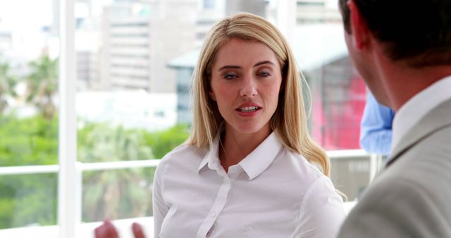 Businesswoman Engaging in Conversation with Colleague in Modern Office Setting - Download Free Stock Images Pikwizard.com