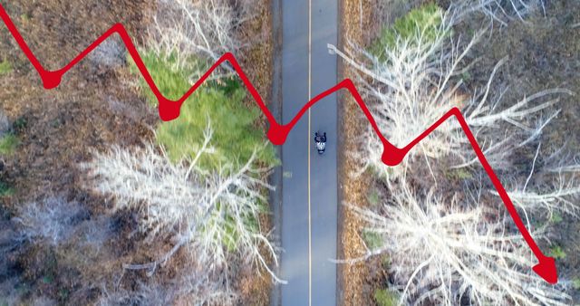 Aerial view of a forest road with a person riding a motorcycle. Superimposed red line graph indicating a business decline runs across the scene. Ideal for illustrating concepts of economic downturn, financial struggles, recession, and challenges in business projections.