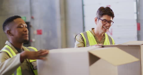 Workers Collaborating in Warehouse Packing Boxes