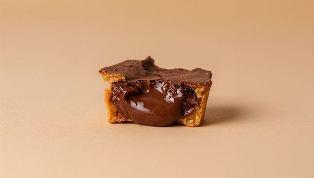 Chocolate tart oozing glossy ganache from crisp shortcrust, closeup food styling