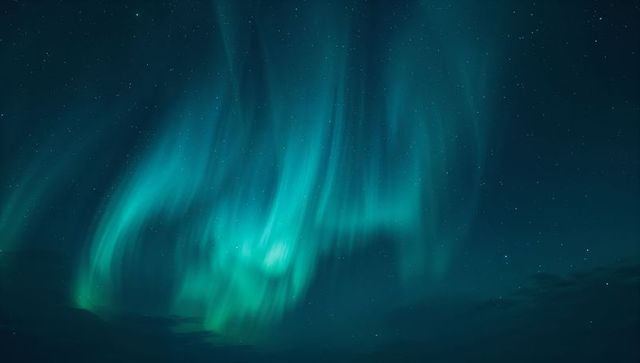 Mesmerizing Green and Teal Northern Lights Over Starlit Sky