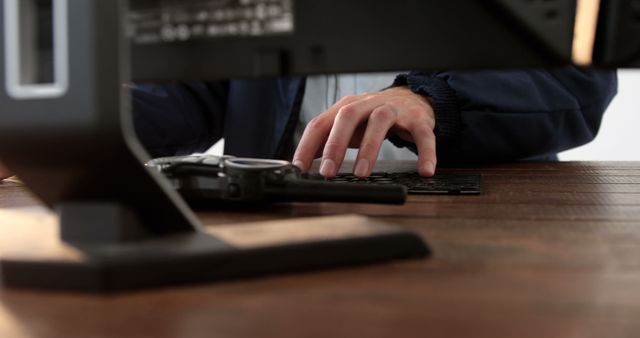 Close-up view of an individual typing on a keyboard at a wooden desk. Ideal for illustrating professionalism, modern work environments, and technology use in business settings. Suitable for articles on office productivity, modern workspace, or digital transformation.