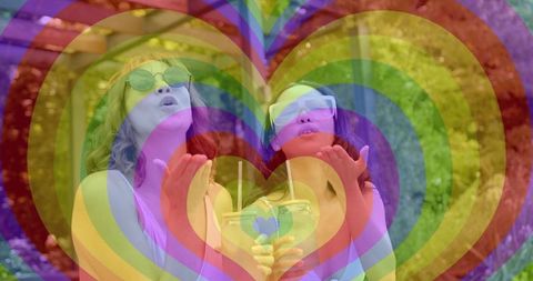Women blowing kisses holding heart jar with rainbow hearts overlay on backyard patio