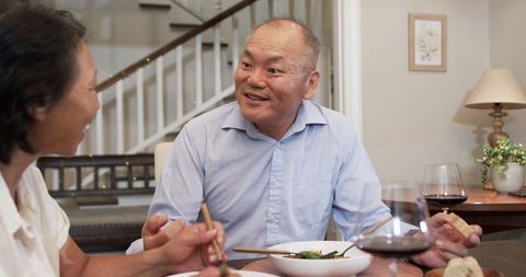 Elderly Couple Enjoying Dinner and Lively Conversation at Home