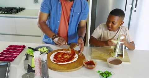 Father and Son Making Pizza at Kitchen Island Combinatively