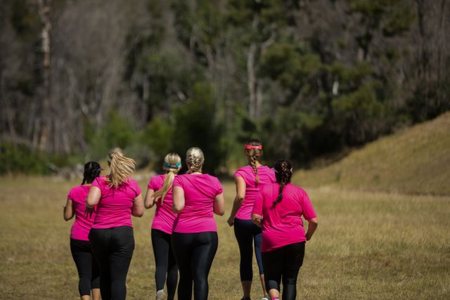 Group of women jogging together in the boot camp on a sunny day
