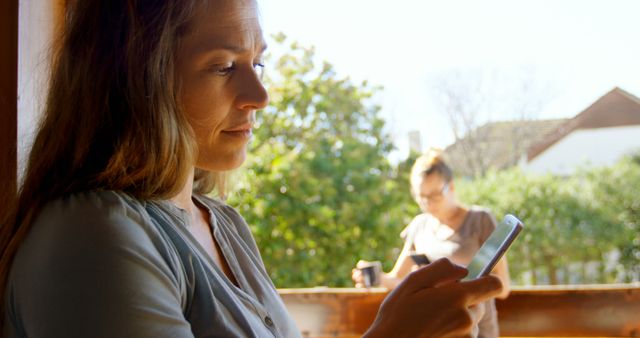 Woman Reading Smartphone Enters Focus, Outdoors Daytime Setting - Download Free Stock Images Pikwizard.com