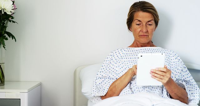 Mature Woman in Hospital Gown Using Tablet - Download Free Stock Images Pikwizard.com