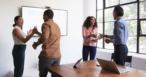 Celebratory Business Meeting with Diverse Colleagues in Modern Office