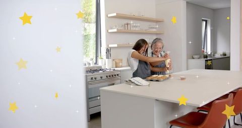 Mother and teen decorating cupcakes together in bright modern kitchen