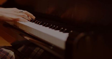 Close-up of Hands Playing Piano Keys in Warm Lighting